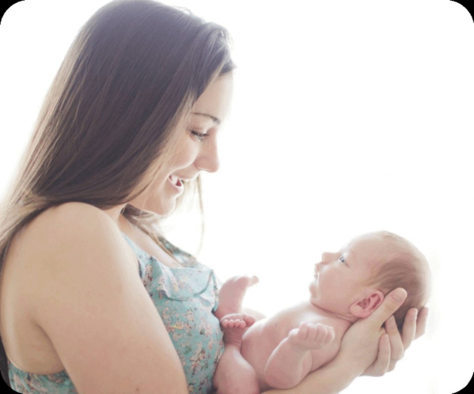 Christina Buchanan, certified nurse midwife, smiling at a newborn she is holding